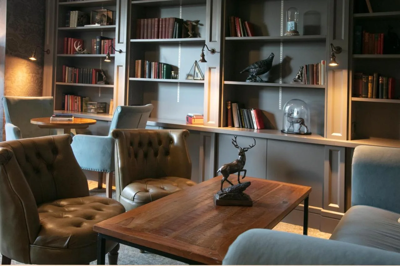 A room with a table, chairs and bookshelves at Lansdown Grove Hotel in Bath