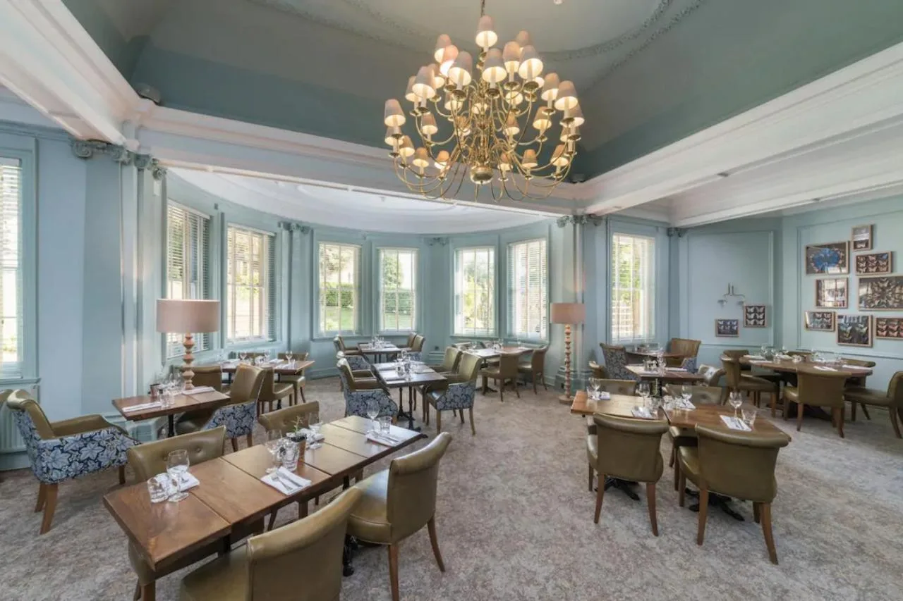A dining room with tables, chairs and a chandelier at Lansdown Grove Hotel in Bath